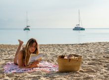 Frau liest am Strand