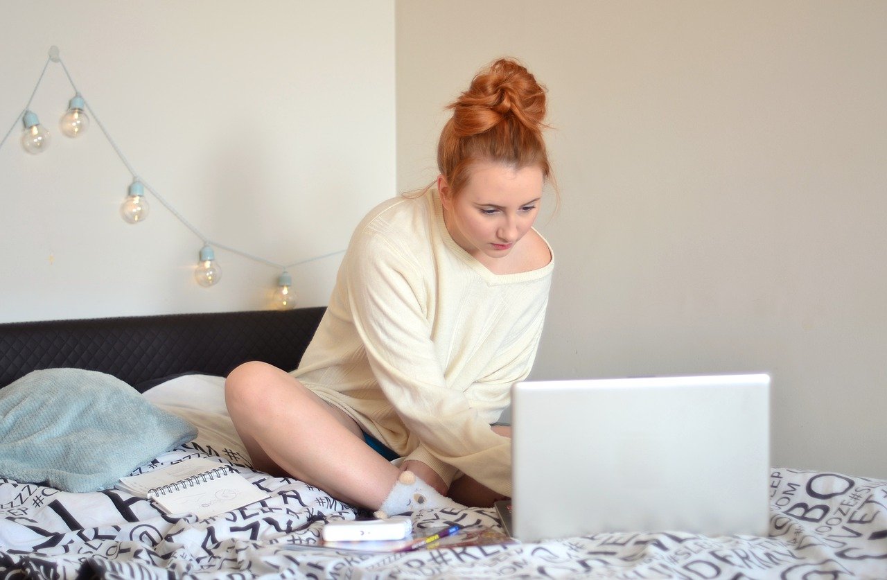 Frau im Bett mit Laptop