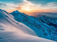 Sonne im verschneiten Gebirge