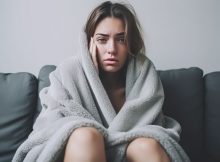Frau mit Decke auf dem Sofa Grippemythen