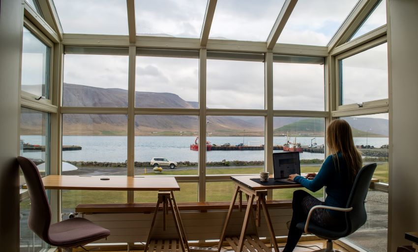 Frau am Laptop mit Aussicht aufs Wasser