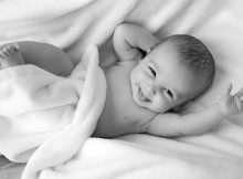 Baby lacht aus den Kissen