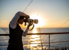 Fotograf an Bord eines Kreuzfahrtschiffes zum Sonnenuntergang