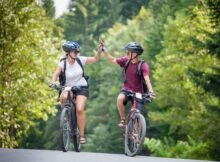 Zwei glückliche Fahrradfahrer klatschen sich ab