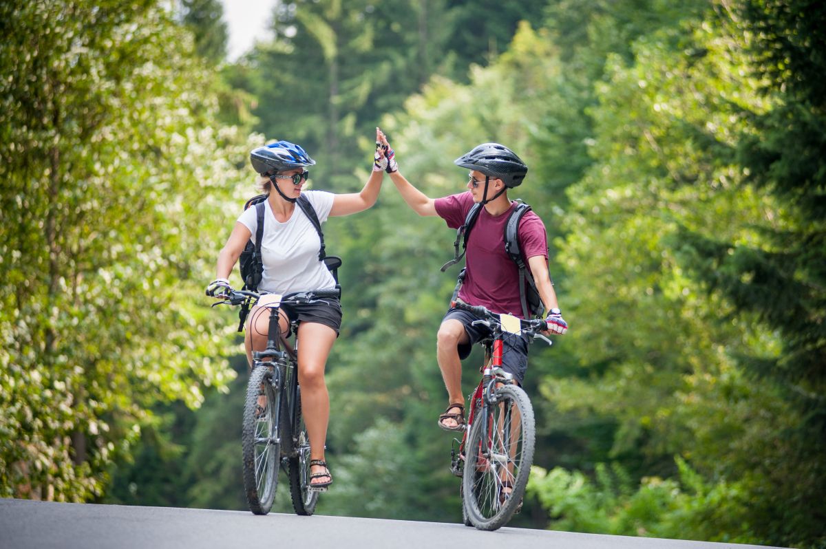 Zwei gl&uuml;ckliche Fahrradfahrer klatschen sich ab